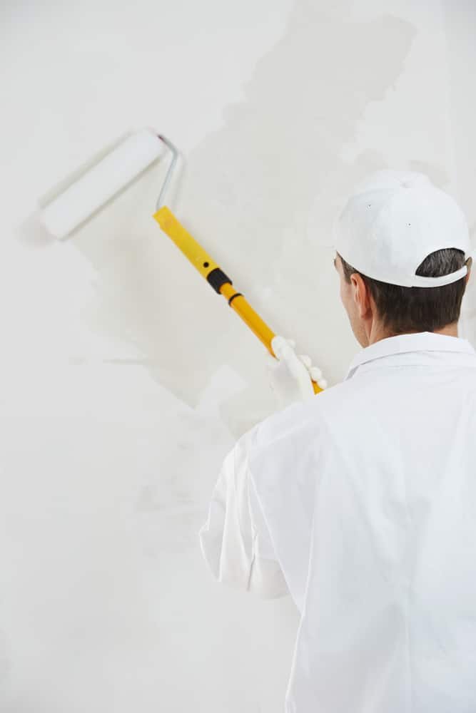 One,Male,House,Painter,Worker,Painting,And,Priming,Wall,With