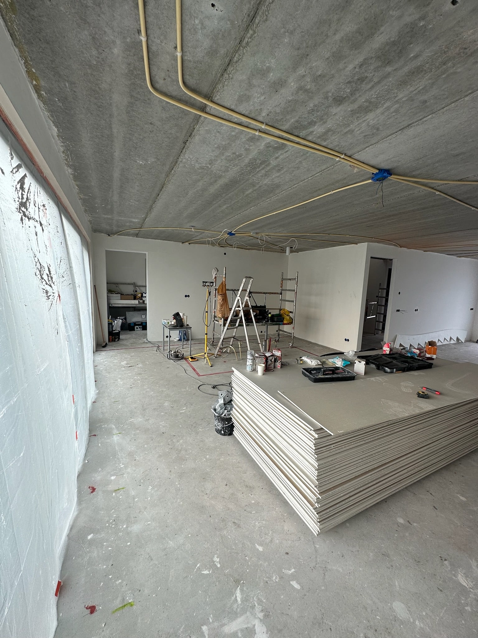 Latex spuiten specialist beoordeelt bouwruimte met plafond en wanden