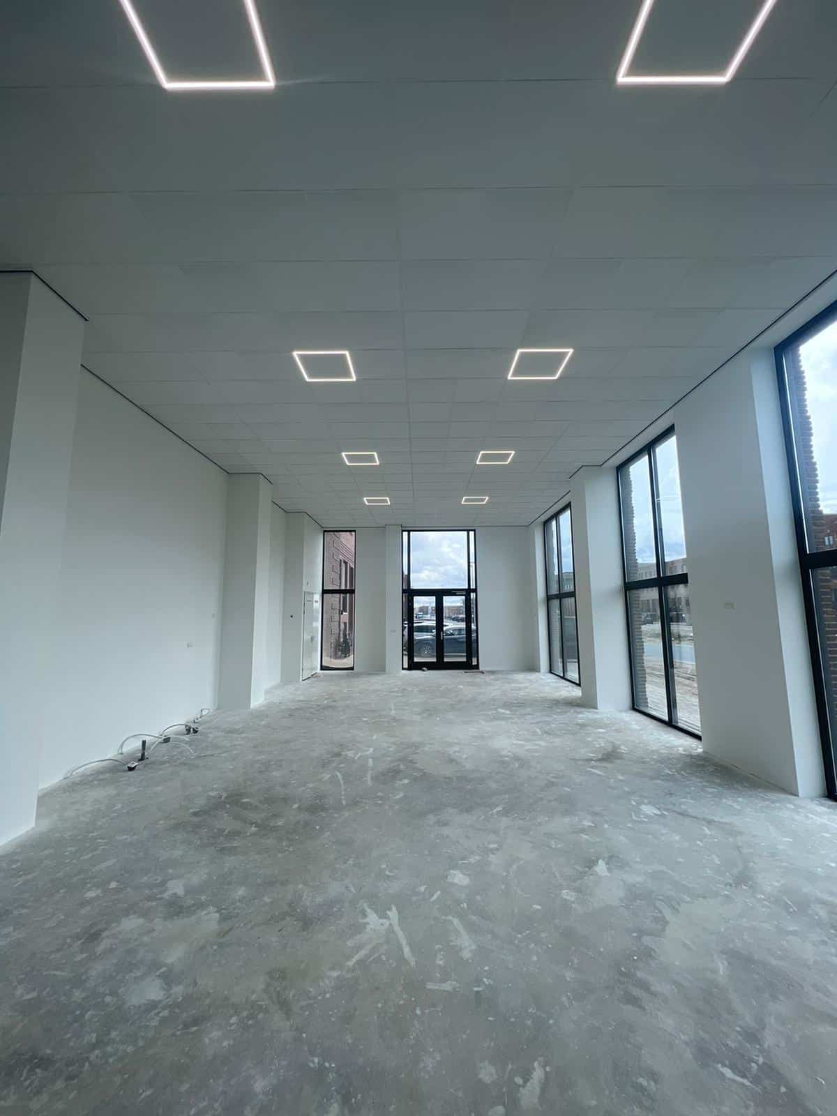 Latex verf spuiten in lichte kantoorruimte met strak plafond en wanden