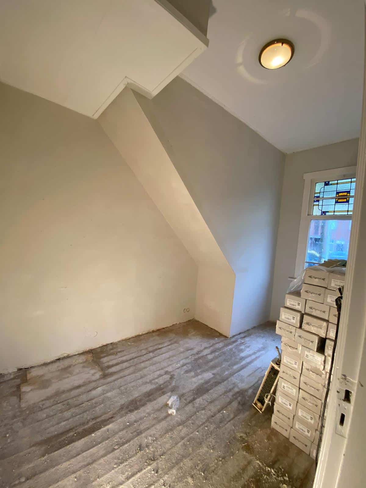 Strak stucwerk op schuine wand en plafond in zolderkamer